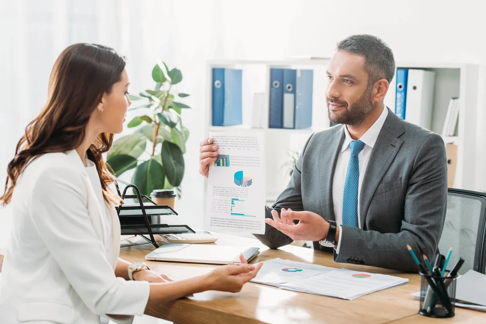 Berater im Gespräch mit einem Bauarbeiter im Büro