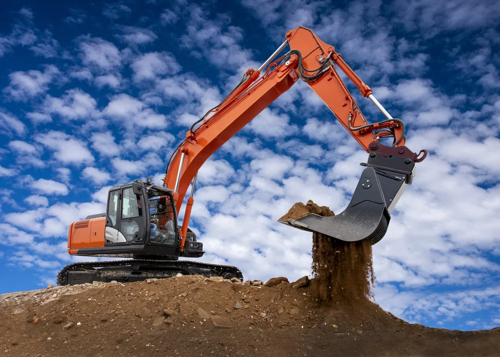 Baumaschinenführer mit Bagger auf der Baustelle